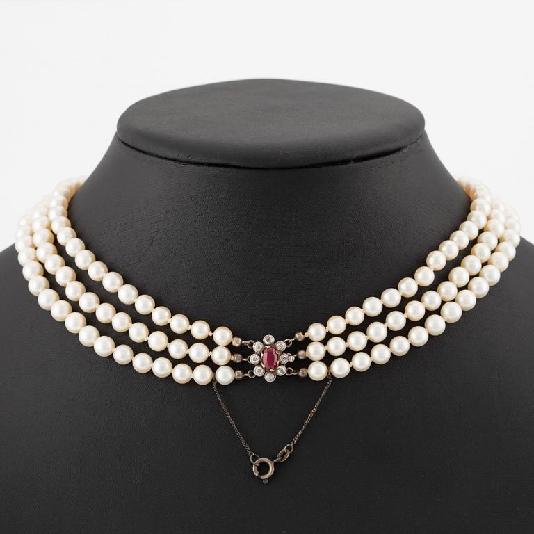 Pearl necklace, three strands, with graduated cultured pearls, gold set with old-cut diamonds and synthetic ruby.