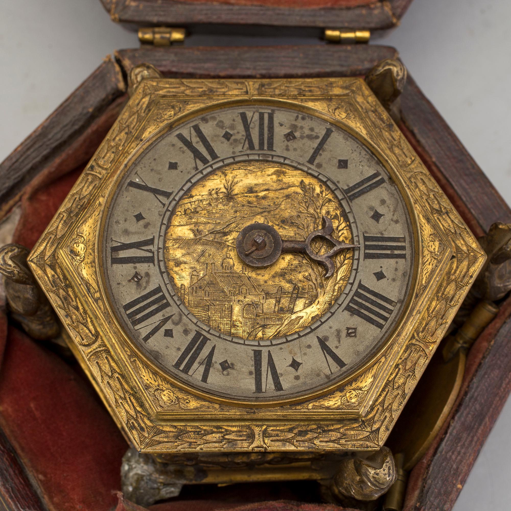 A gilded brass baroque travel clock from around 1700, with original case.