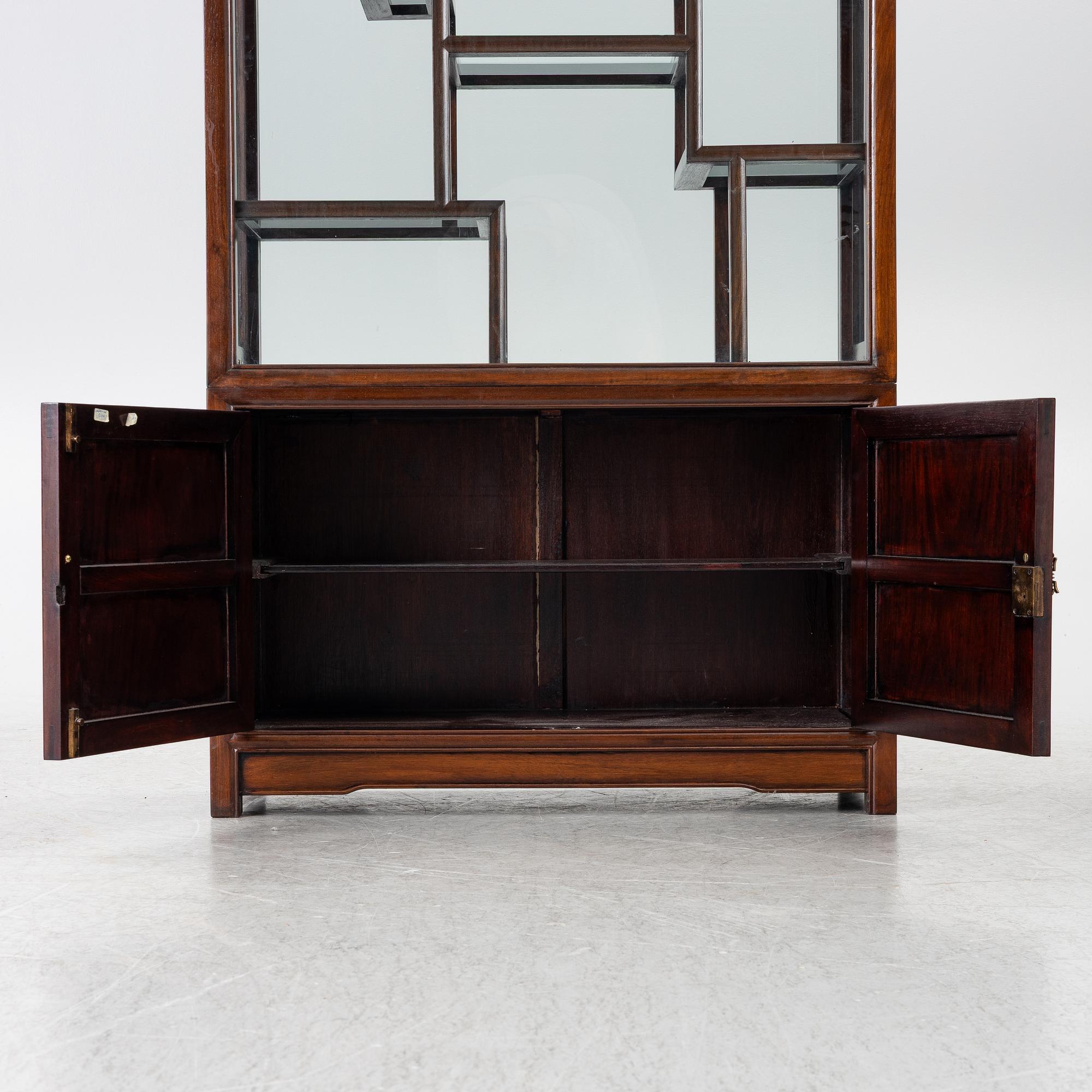 A Chinese display cabinet, wood and glass, later part of the 20th century.
