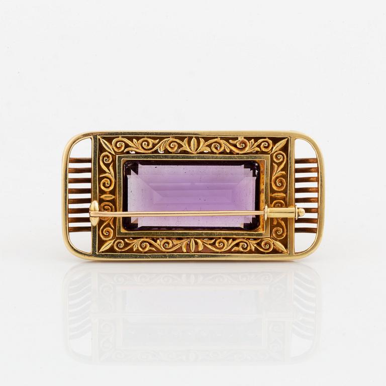 A 14K gold brooch set with a faceted amethyst and eight-cut diamonds.