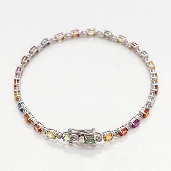 Rannekoru, 18K valkokultaa monivärisillä safiireilla ja timanteilla.