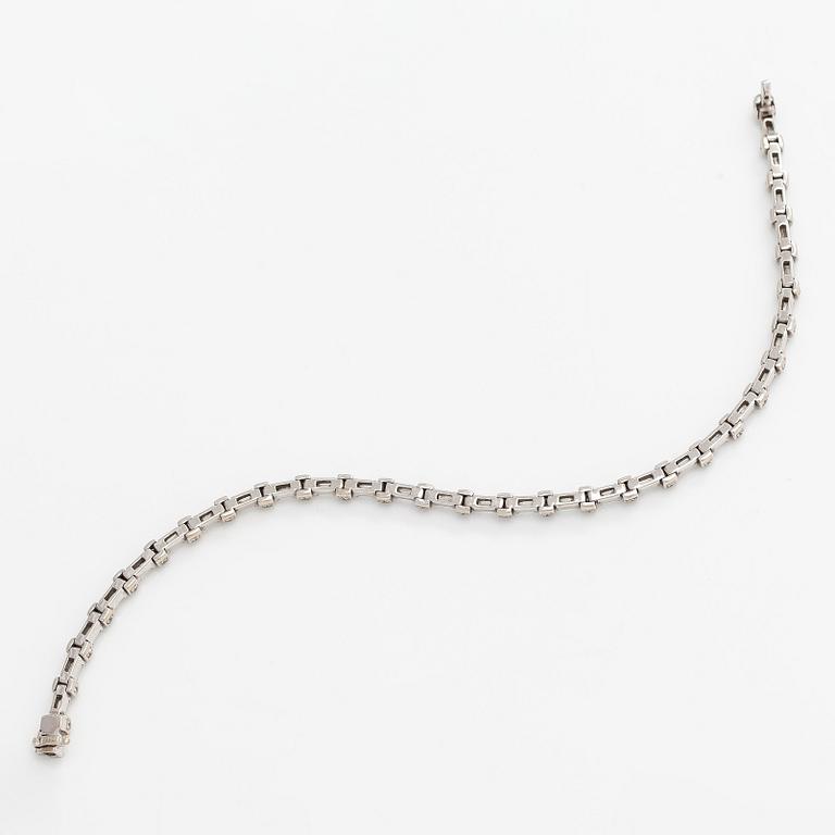 An 18K white gold bracelet set with baguette and brilliant-cut diamonds.