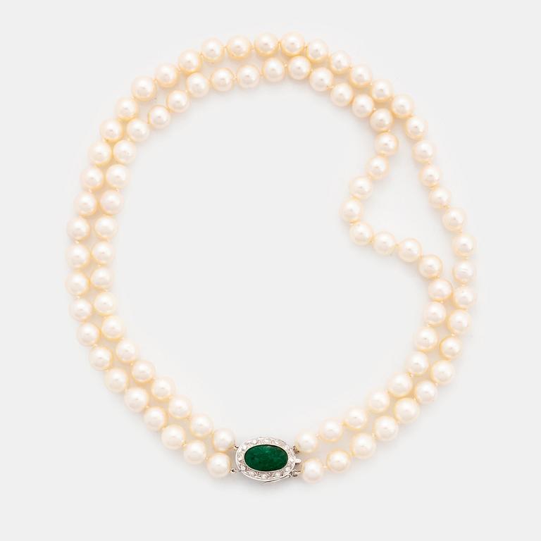 A two strand cultured pearl necklace with an 18K white gold and emerald clasp.