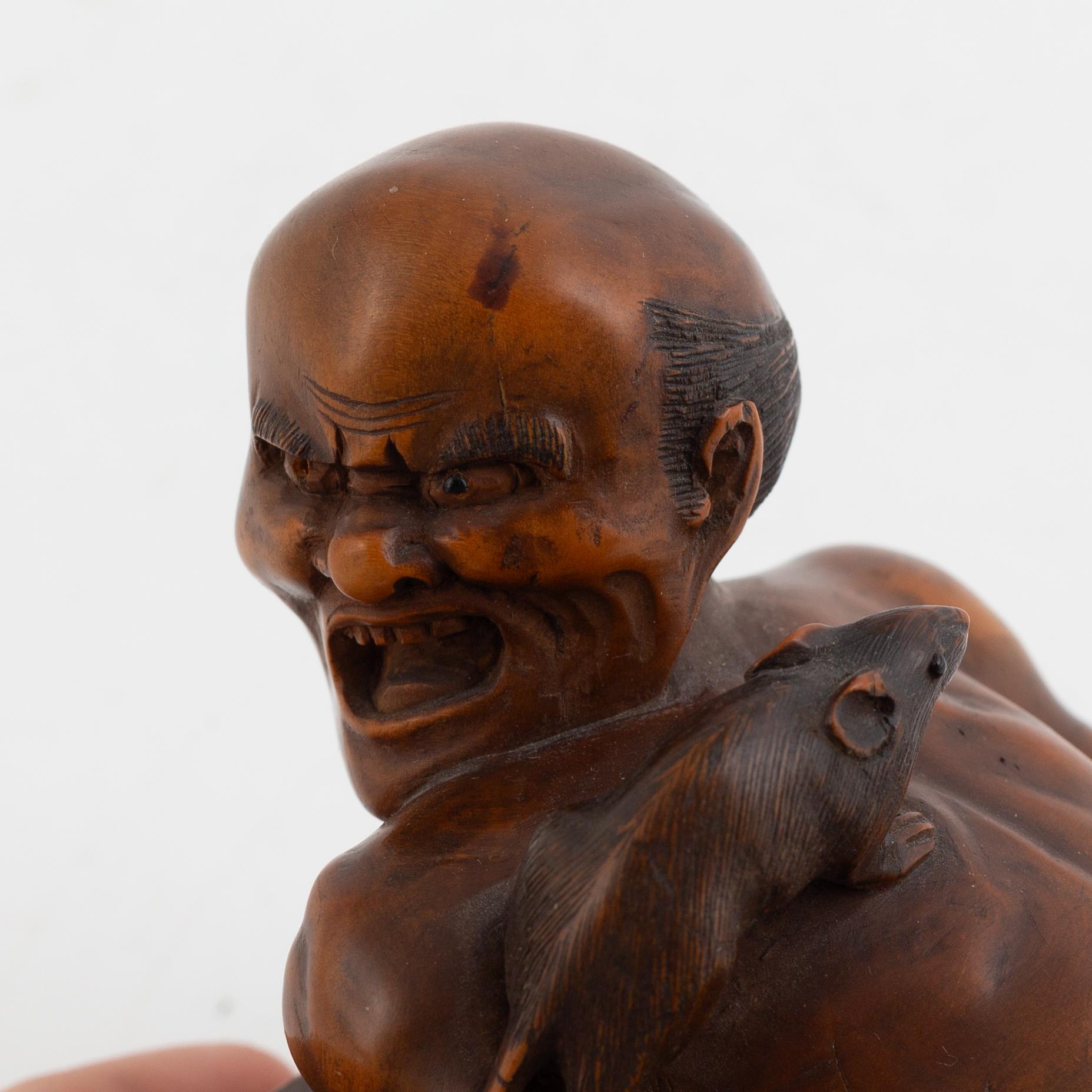 A Japanese mei boxwood okimono of a rat catcher. Meiji period.