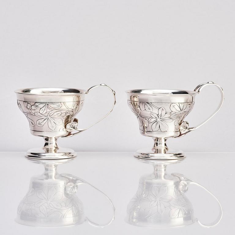 Teodor Werner & Co, ett par tekoppar med fat och skedar, silver, sannolikt Warzawa, 1899-1904.