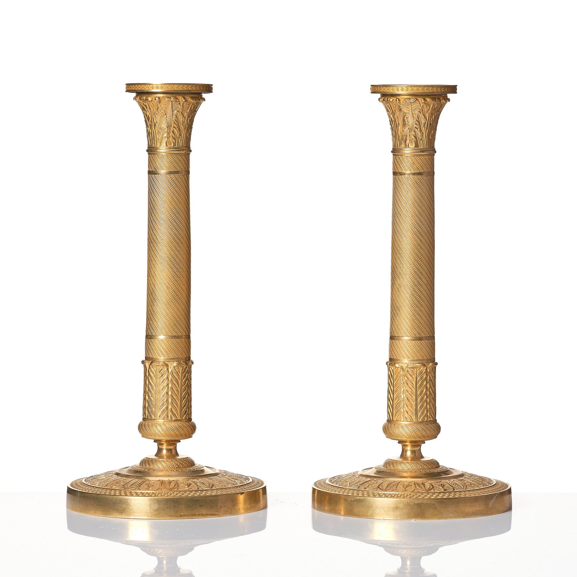 A pair of French Empire ormolu candlesticks, early 19th century.