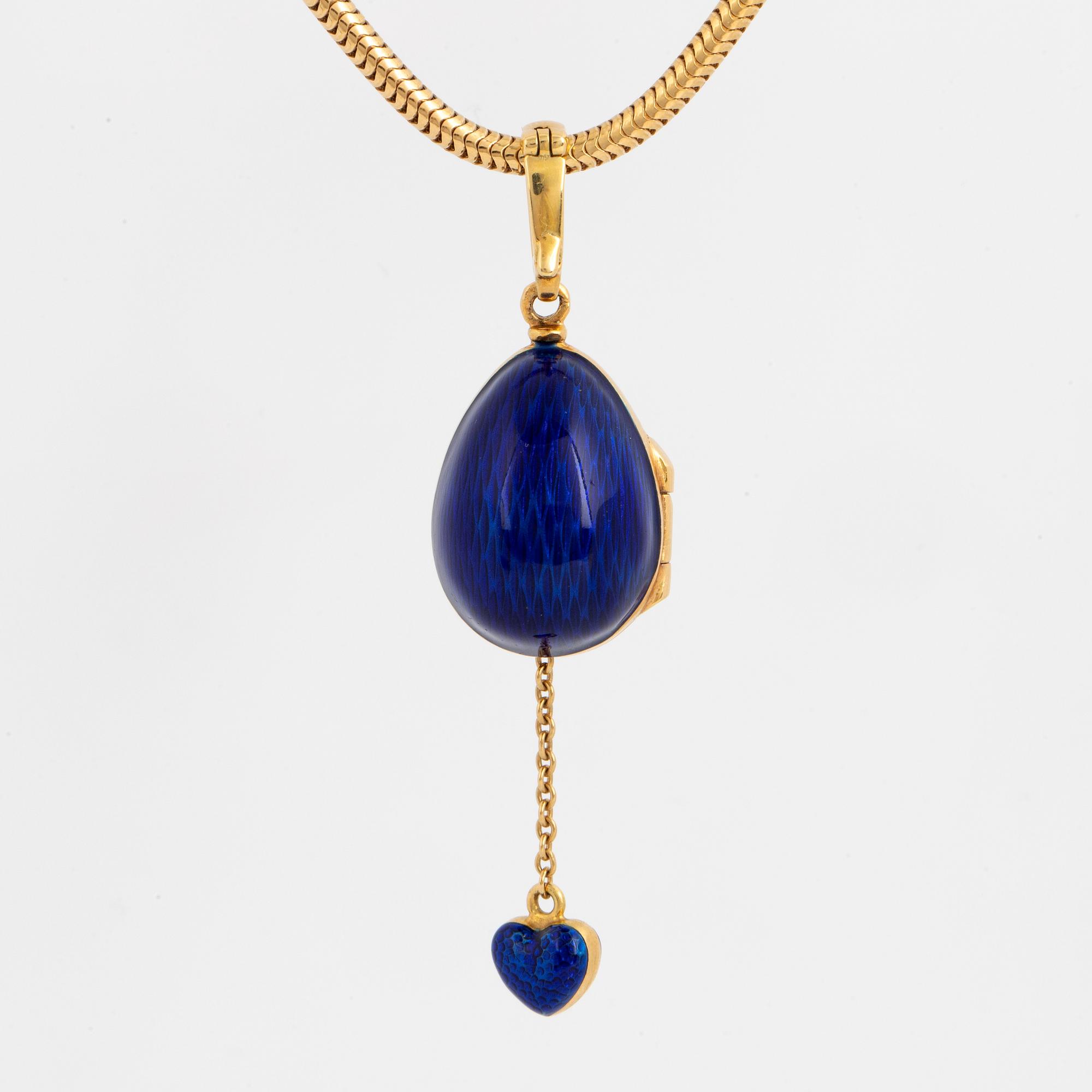 FABERGÉ-ÄGG, 18K guld med blå emalj och runda briljantslipade diamanter, med kedja, med etui.