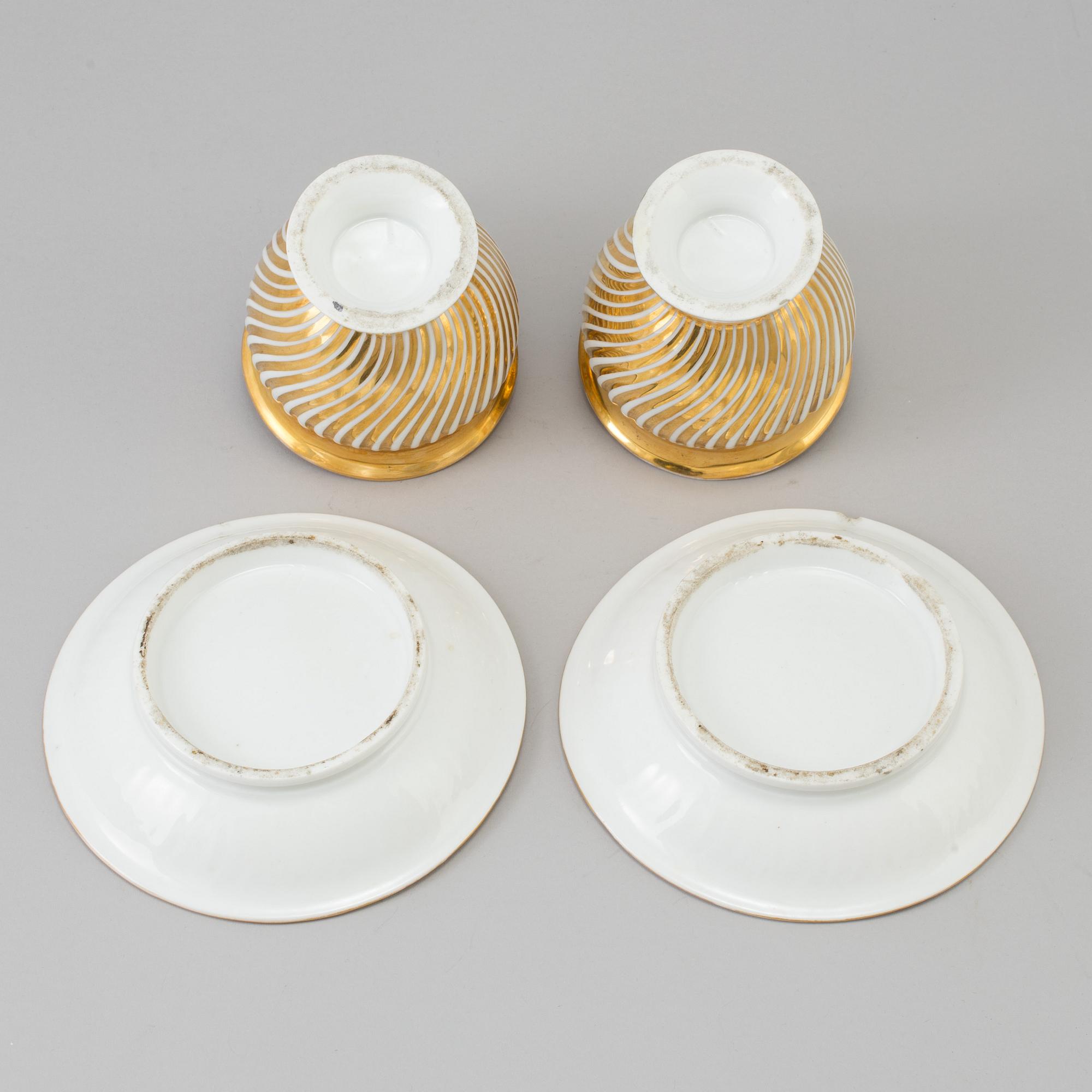 a pair of late empire porcelain cups with saucers from the first half of the 19th century.