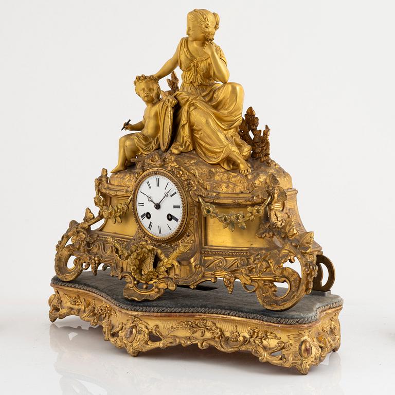 A table clock and a pair of candelabras, Louis XVI-style, France, beginning of the 20th century.