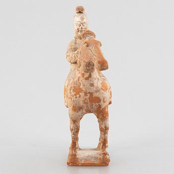 A painted pottery figure of an equestrian standard-bearer, Tang dynasty (618-907 AD.).