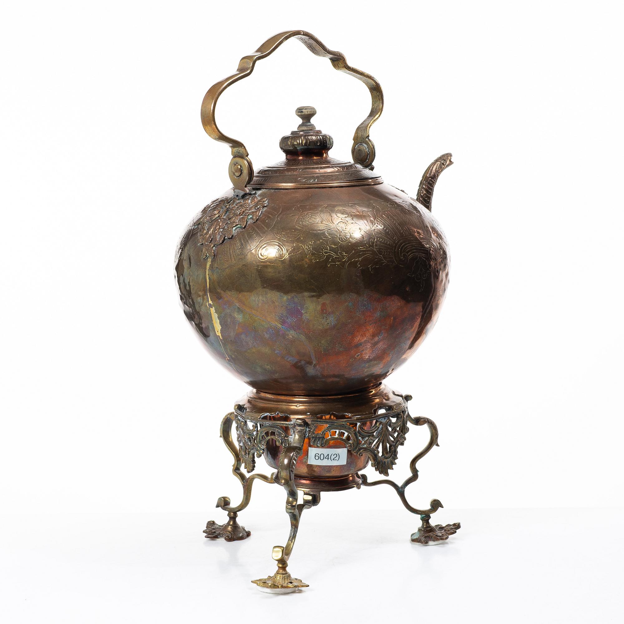 A German Rococo repoussé copper teapot on rechaud, mid 18th century.