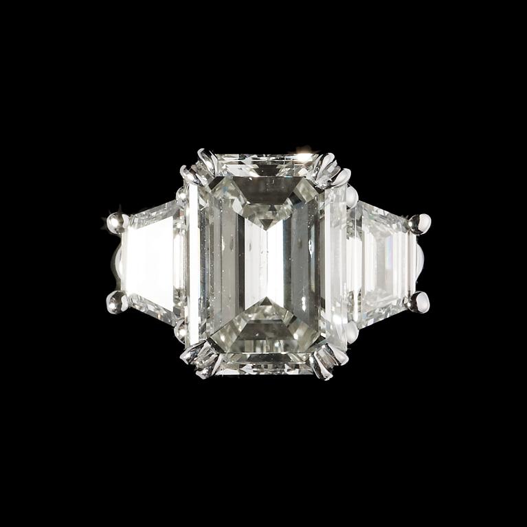 RING, smaragdslipad diamant, 3.01 ct samt på vardera sida trapezslipad diamant, tot. ca 0.80 ct.