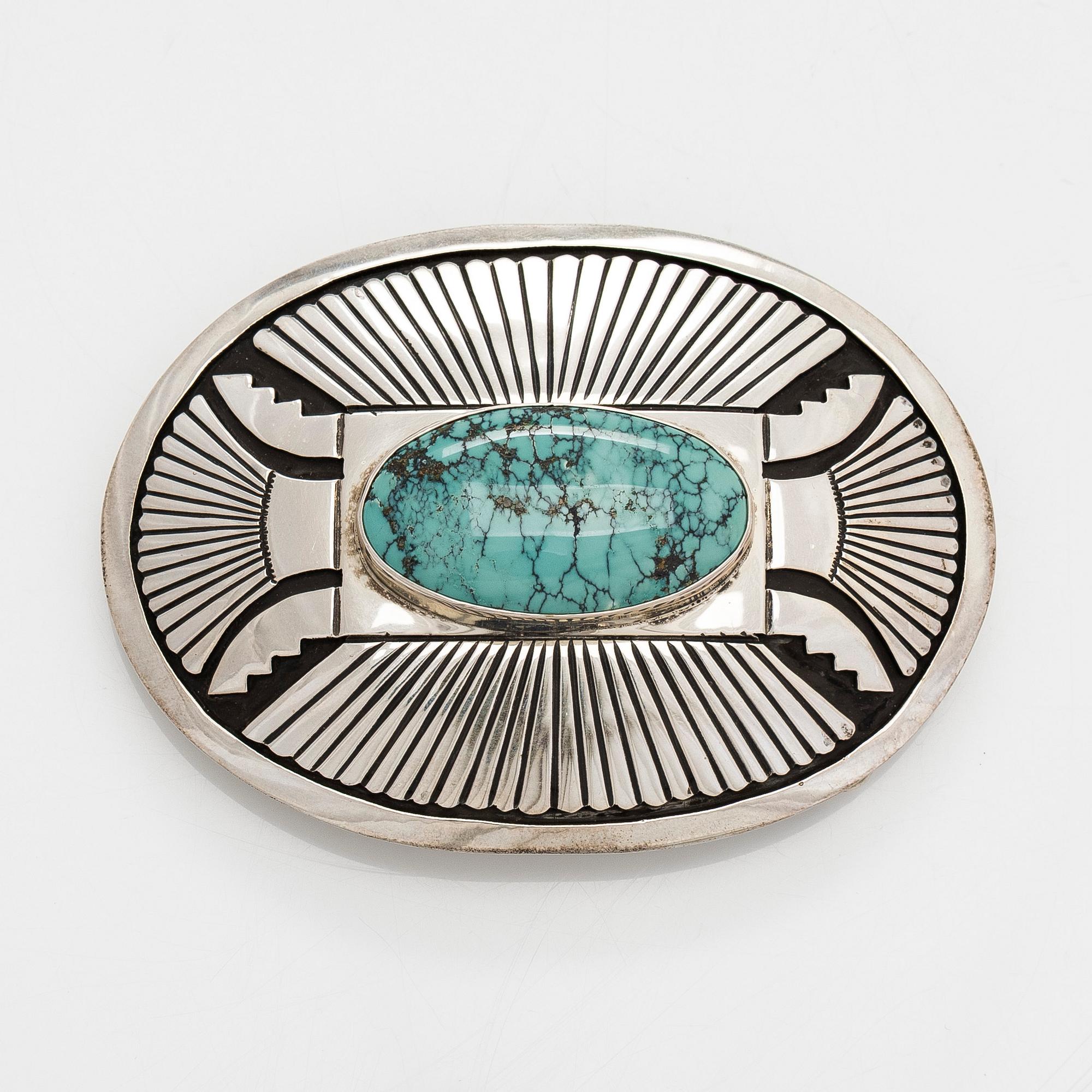 Chester Benally, a silver belt buckle with a turquoise, Navajo.