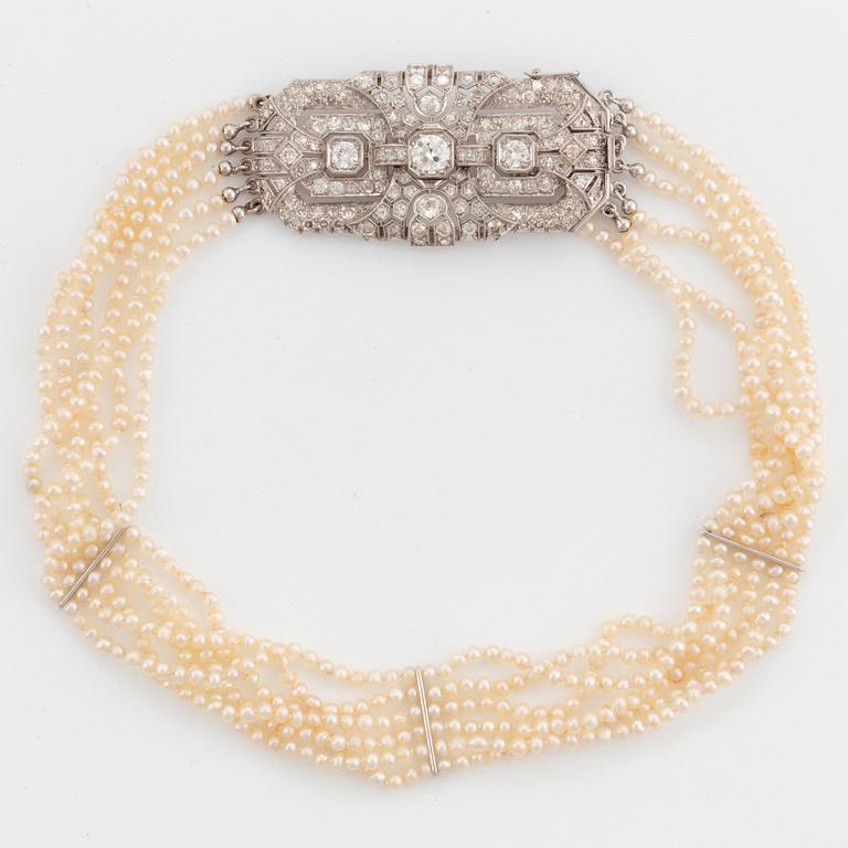 A six strand pearl necklace with a clasp in platinum and 18K white gold set with old- and eight-cut diamonds.