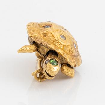 A brooch in the shape of a turtle.