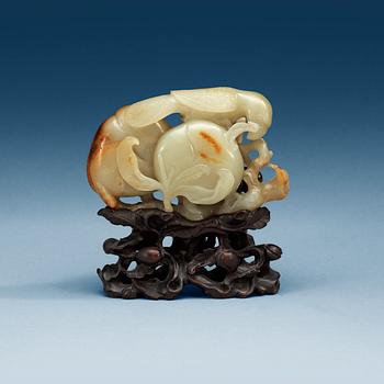 A carved nephrite figure of a parrot among peaches, Qing dynasty.