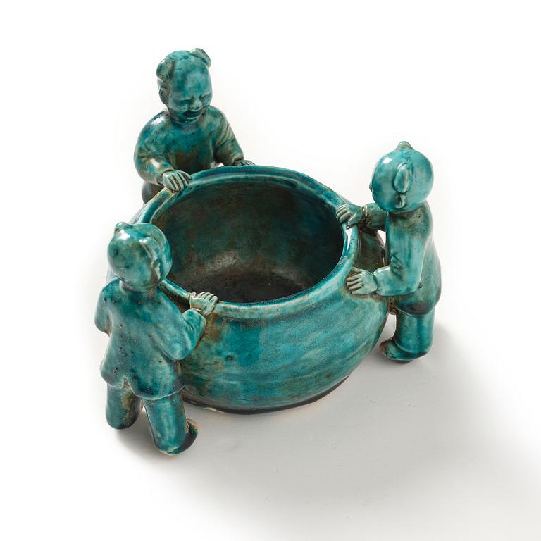 A turquoise glazed vessel supported by a group of boys, Qing dynasty, Kangxi (1662-1722).