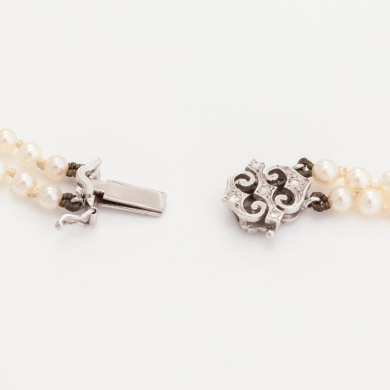 An 18K white gold necklace with cultured pearls, enamel and brilliant-cut diamonds. England.