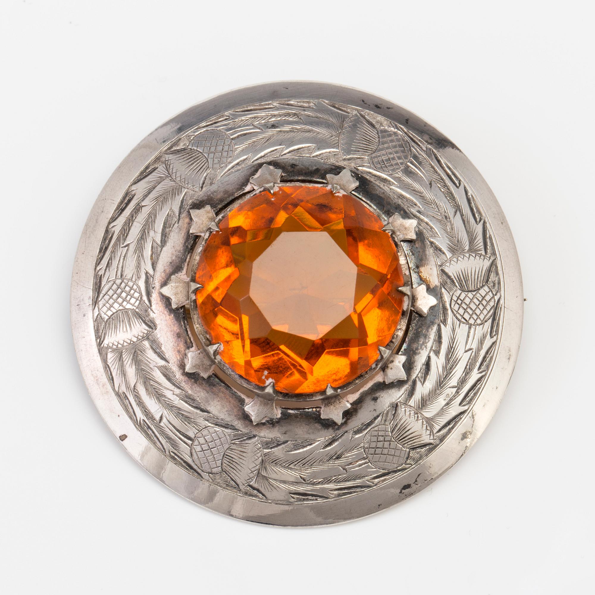A BROOCH set with amber coloured paste.