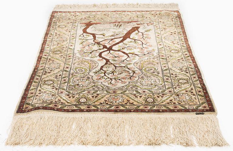 A semi-antique / old silk Hereke rug, West Anatolia, c. 100 x 60 cm.