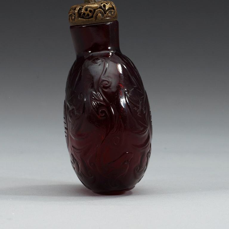 A large red sculptured peking glass snuff bottle with stopper, presumably around 1900.