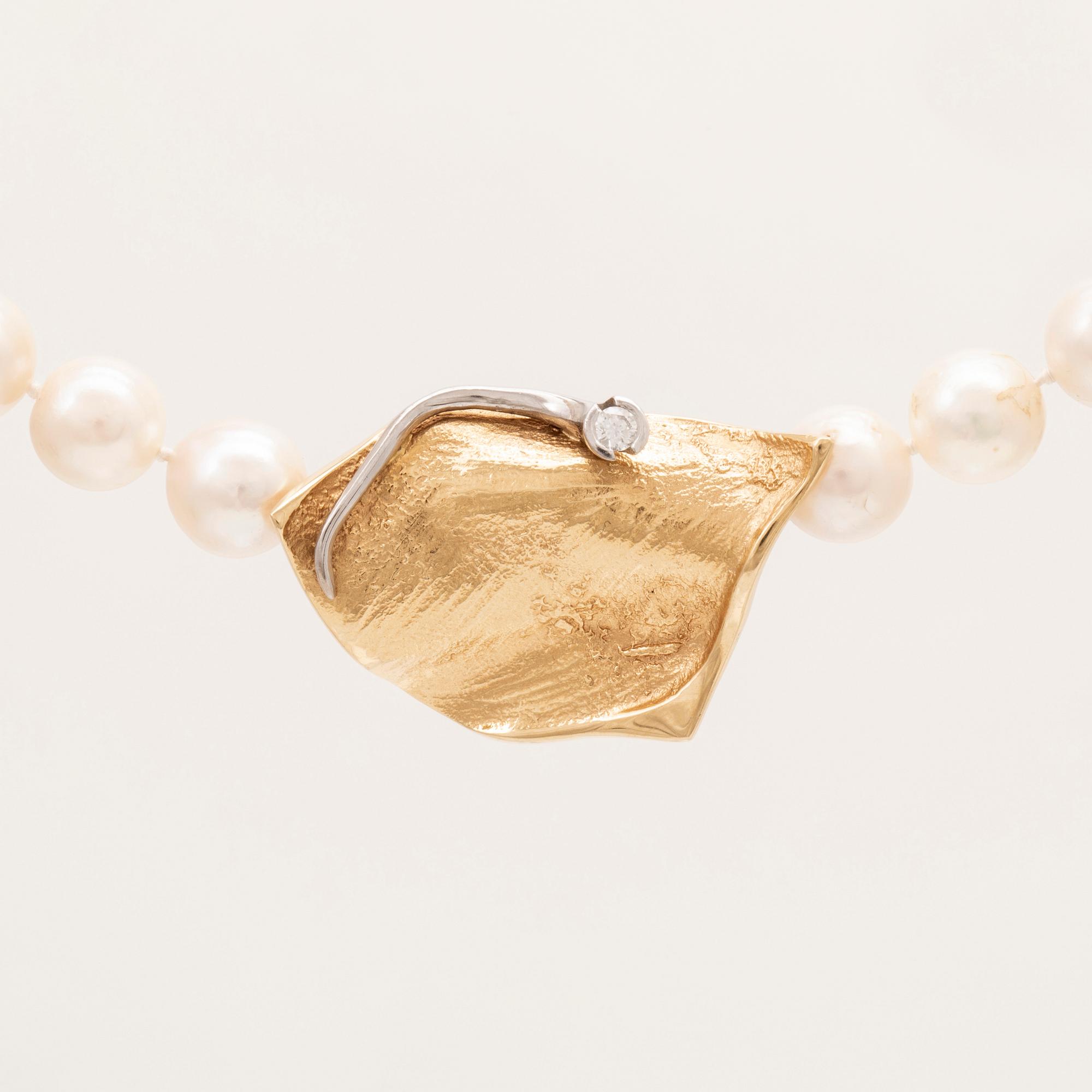 A necklace of cultured pearls, lock in 18K white and red gold set with a round brilliant cut diamond by Ole Lynggaard.