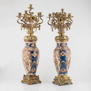 A pair of gilt-brass and satsuma ware seven-light candelabra, the porcelain Meiji period (1868-1912).