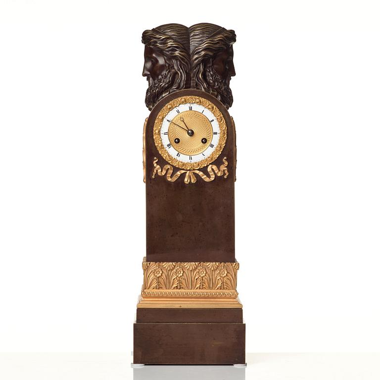 An Empire early 19th century gilt and patinated bronze mantel clock.