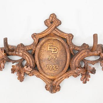 Wall-mounted coat rack dated 1933.