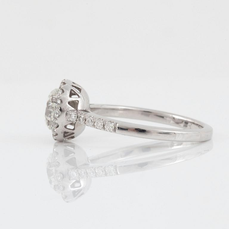 A brilliant-cut diamond ring. Center stone 1.03 cts F/VS1, surrounded by 0.36 ct pavé-set diamonds.