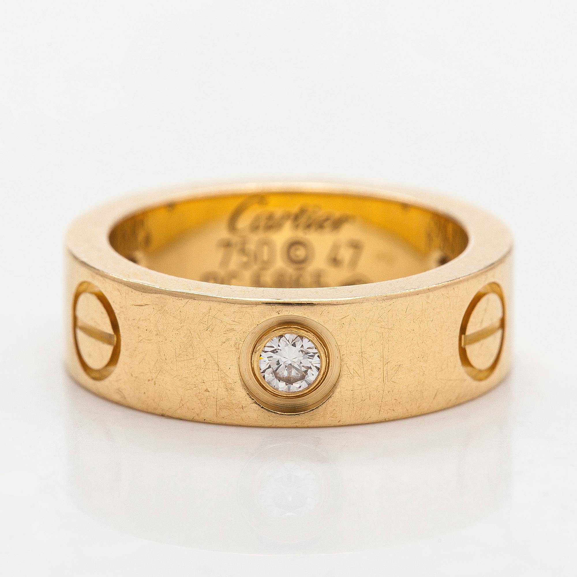 Cartier, an 18K gold 'Love' ring with three brilliant-cut diamonds.