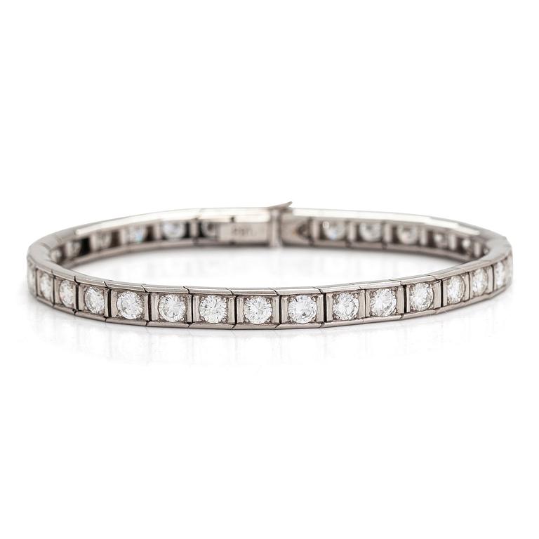 A platinum tennis bracelet with brilliant cut diamonds totalling approx. 5.61 ct. With certificate.