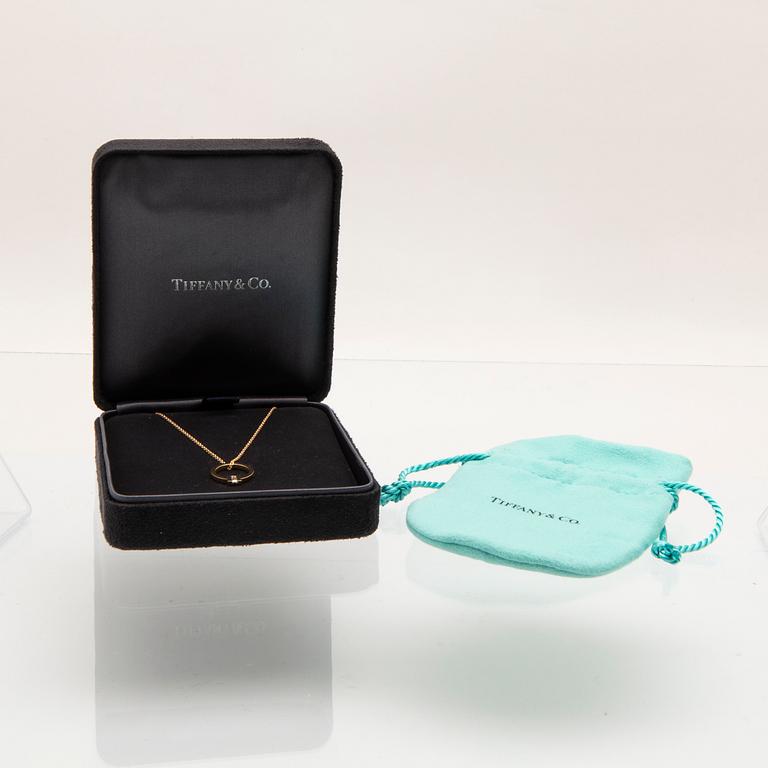 Tiffany & Co, halsband "T" 18K guld med en baguettslipad diamant.