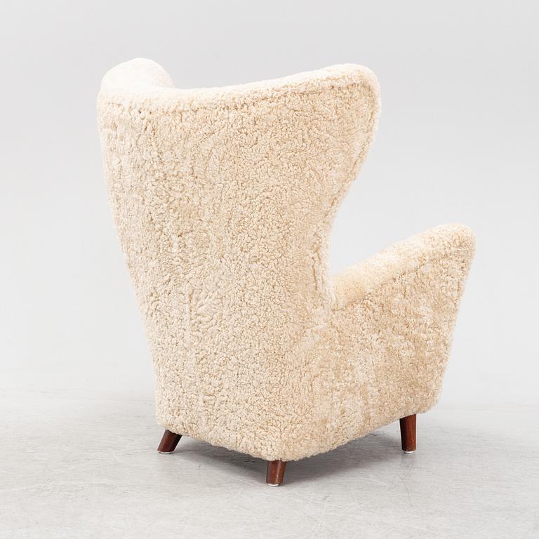 A sheepskin upholstered wing back lounge chair, 1940s.