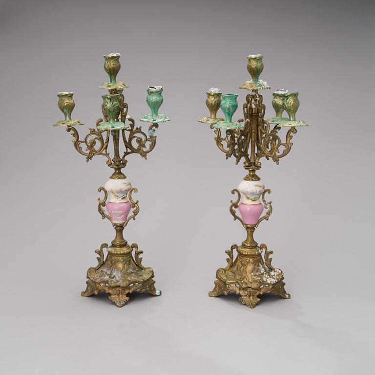 A pair of gilt-bronze Rococo Revival candelabra with porcelain decors, from the latter half of the 19th century.