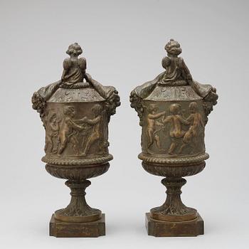 A pair of 19th century bronze urns in the manner of Clodion.