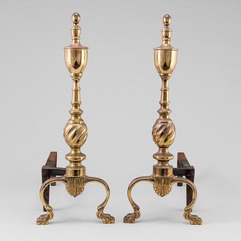 A pair of  ornate brass urn top cast iron fireplace fire dog andirons from around the year 1900.