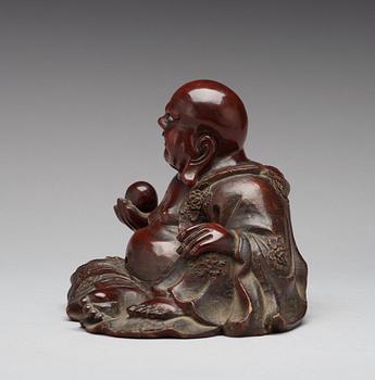 A seated wooden figure of Buddai, Qing dynasty, circa 1900.