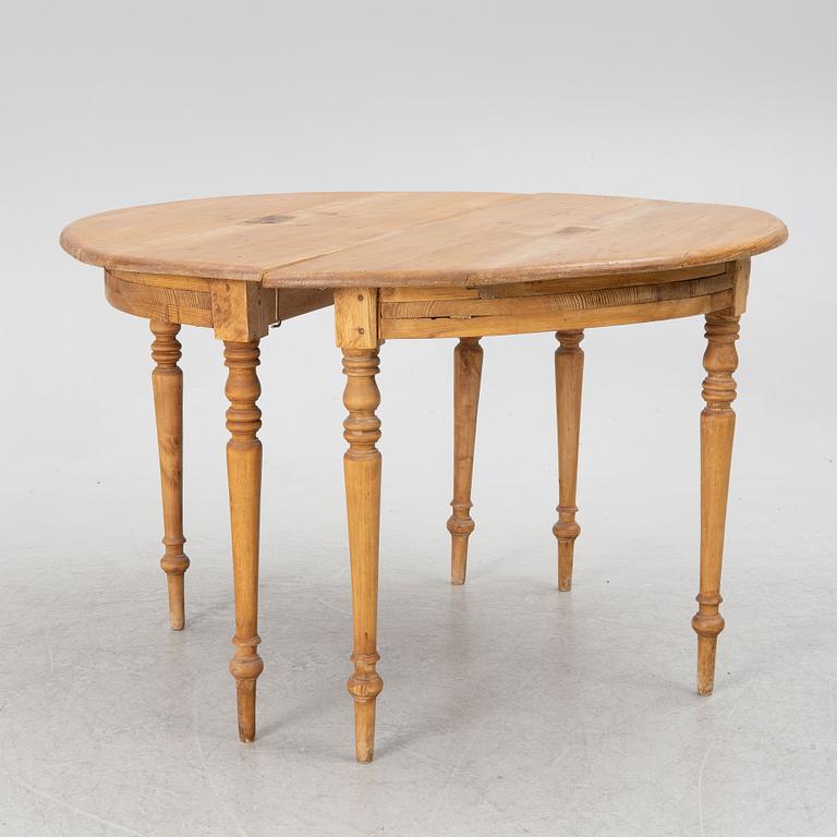 A round pine dining table/a pair of crescent shaped tables, Sweden, 19th century.