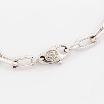 An 18K white gold Cartier "Spartacus" bracelet with two charms.
