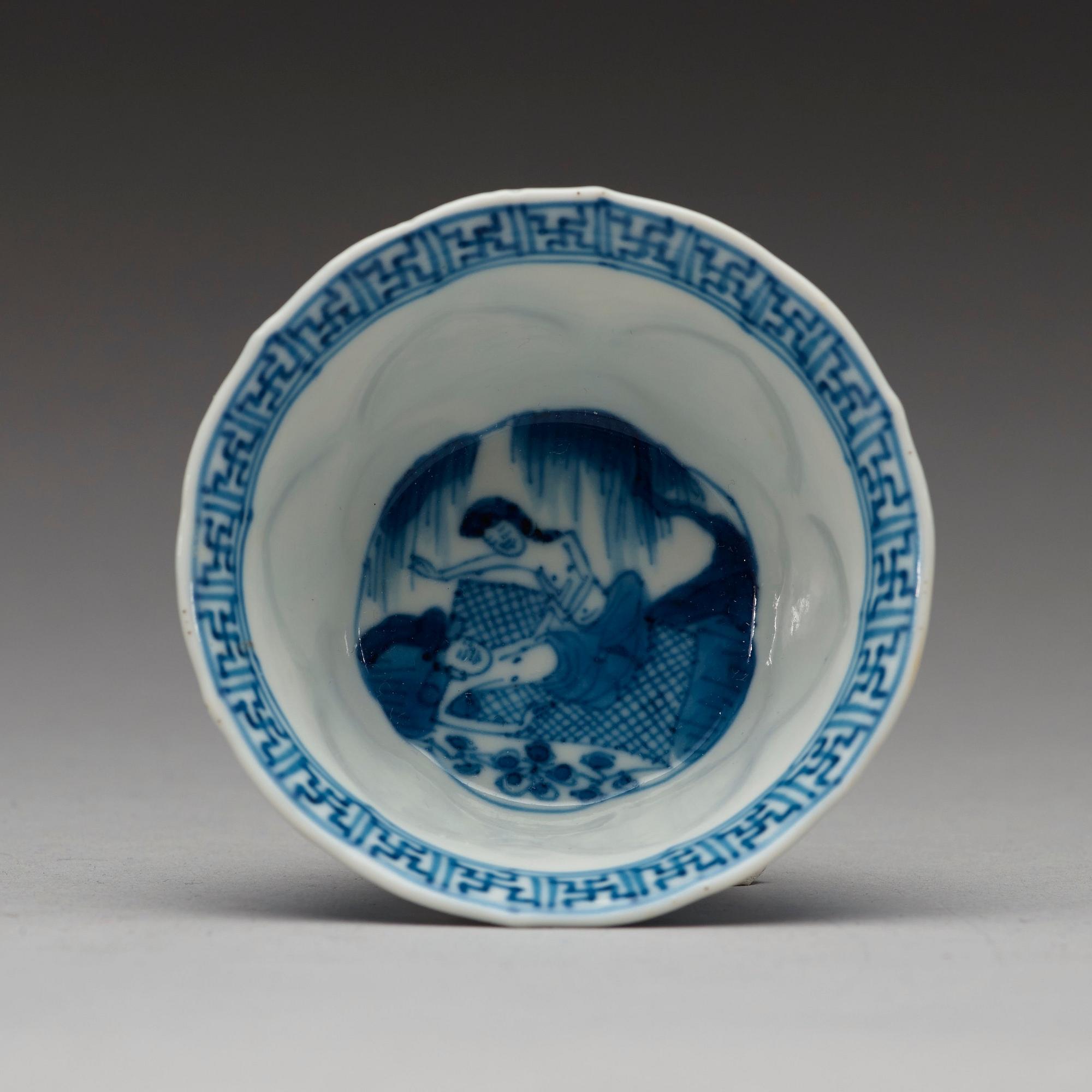 A pair of blue and white "erotic" cups with saucers, Qing dynasty Kangxi (1662-1722).