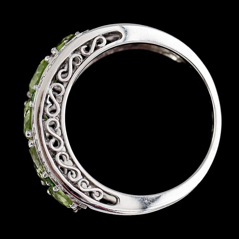 RING, 14K vitguld, peridoter och åttkantslipade diamanter tot ca 0.26 ct. Vikt ca 7 g.