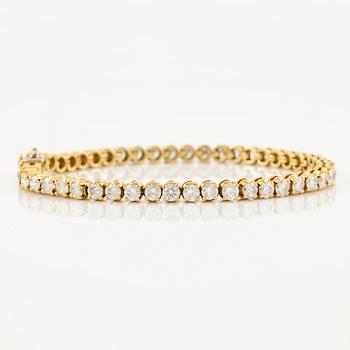 A tennis bracelet in 14K gold with round brilliant-cut diamonds.