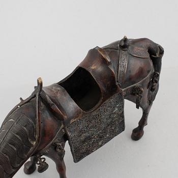 A Chinese bronze and cloissoné figurine on a mule, late Qing/early 20th century.