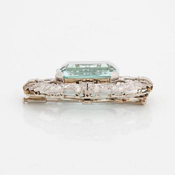 A platinum brooch set with an aquamarine and round brilliant- and eight-cut diamonds.