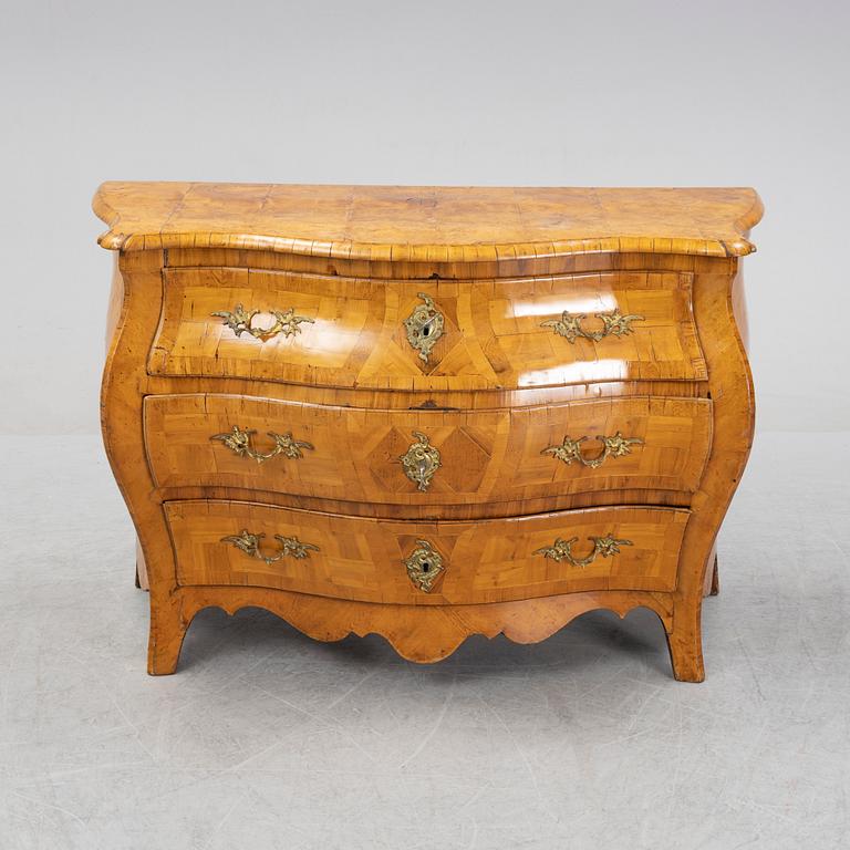 An elm and elm root veneered Rococo chest of drawers, 18th Century.