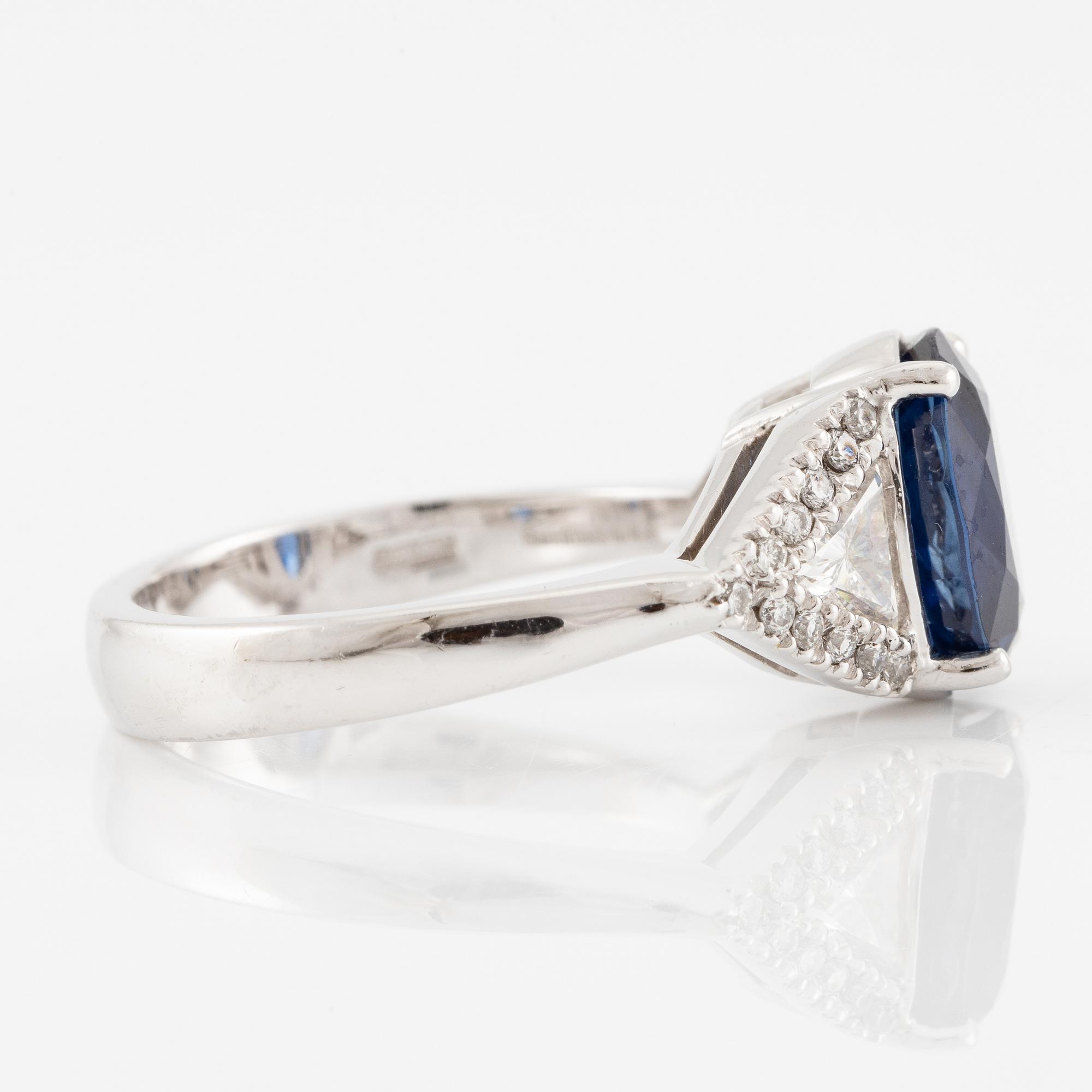 Damiani ring platina med en fasettslipad safir samt triangulära- och runda briljantslipade diamanter.
