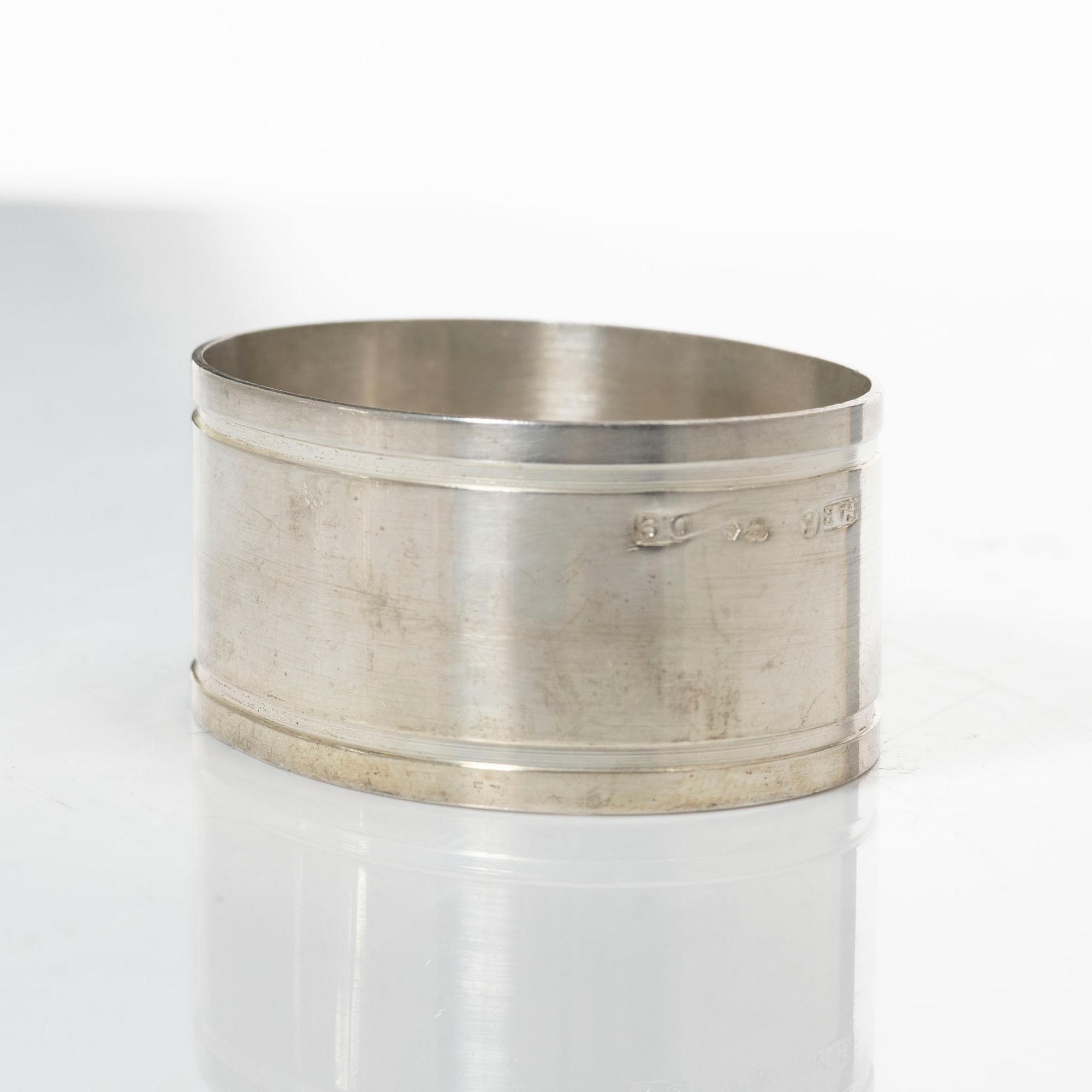 A pair of beakers, two napkin rings, and 17 pieces of cutlery, silver.