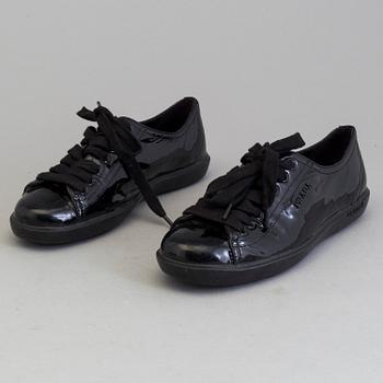 A pair of PRADA black patent leather sneakers.
