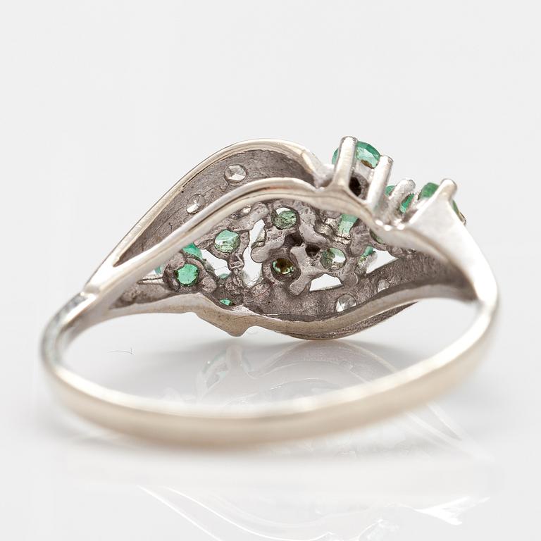 A 14K white gold ring with emeralds and diamonds ca. 0.02 ct in total. Import marked Turun Hopea, Turku 1995.